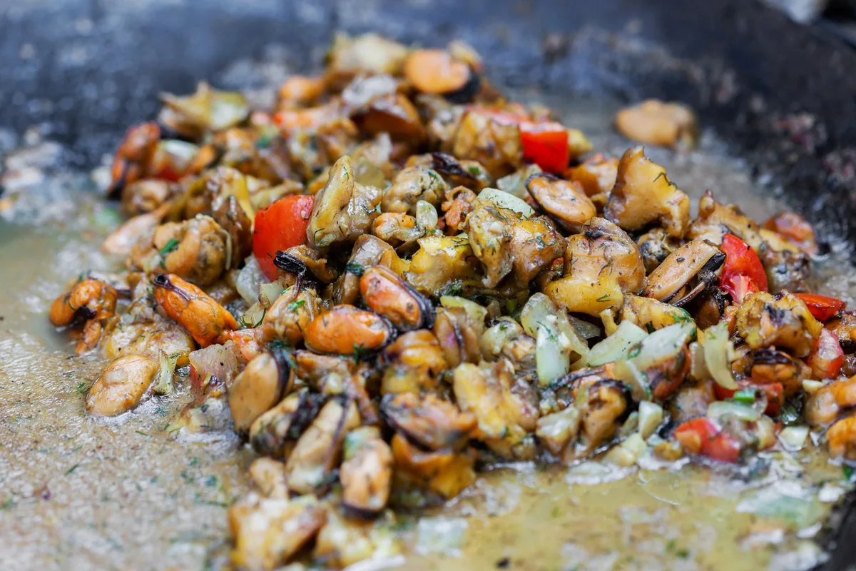 Roasted mixed vegetables glistening on a dark tray