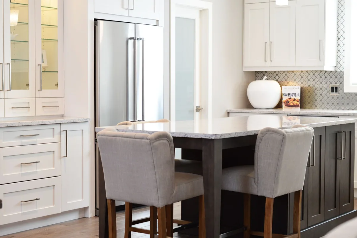 Row of white wall cabinets above a tiled kitchen splashback