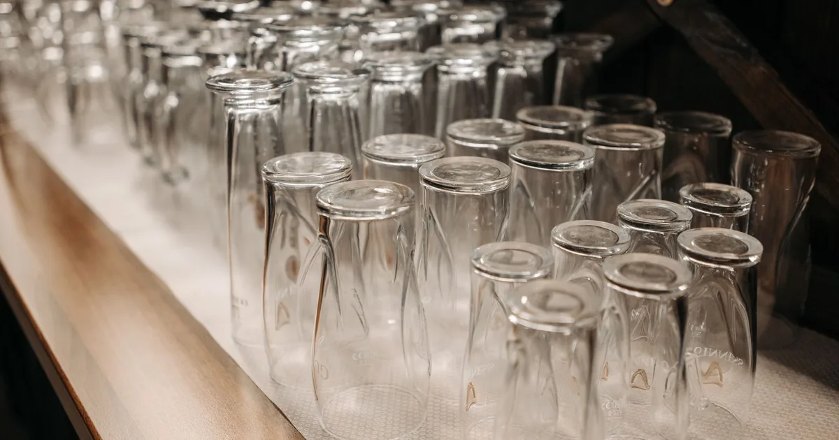 Rows of clean drinking glasses on a shelf