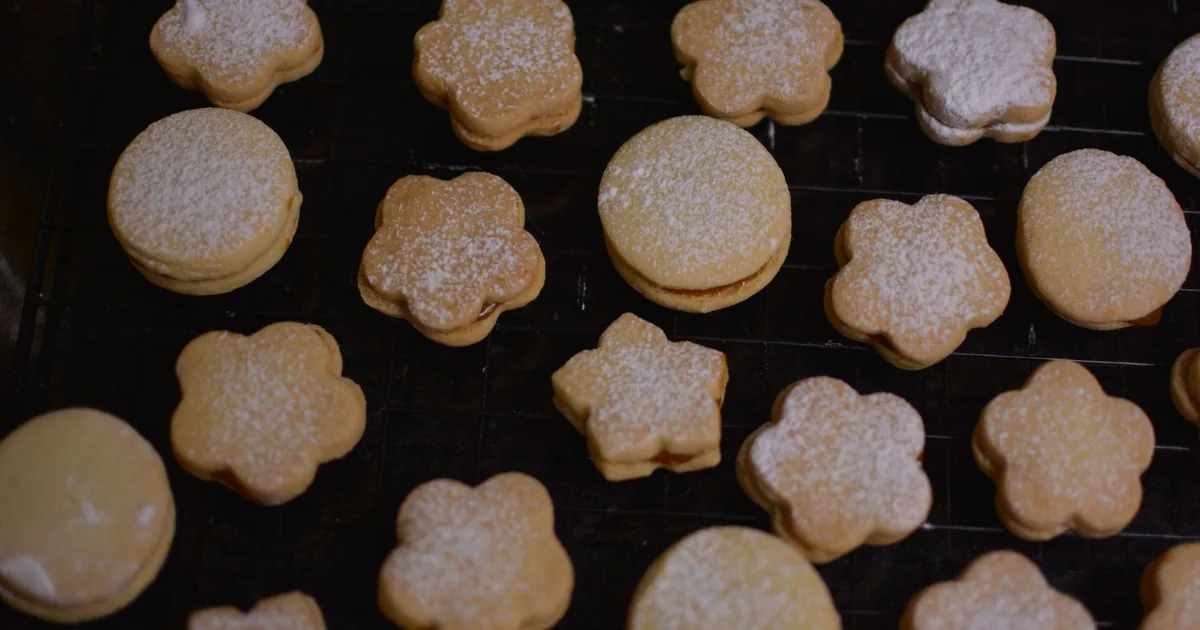 Sandwich cookies cooling on a dark wire rack