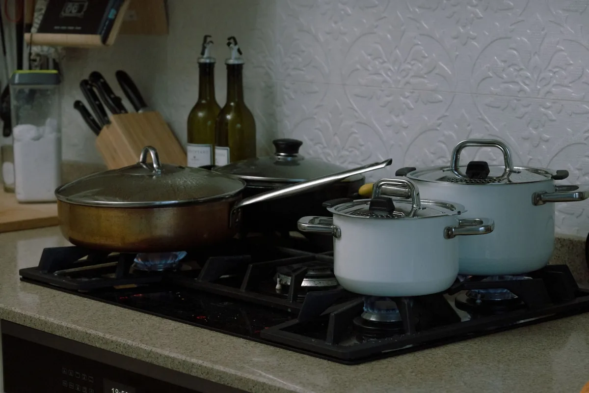Several lidded pots on a gas cooktop