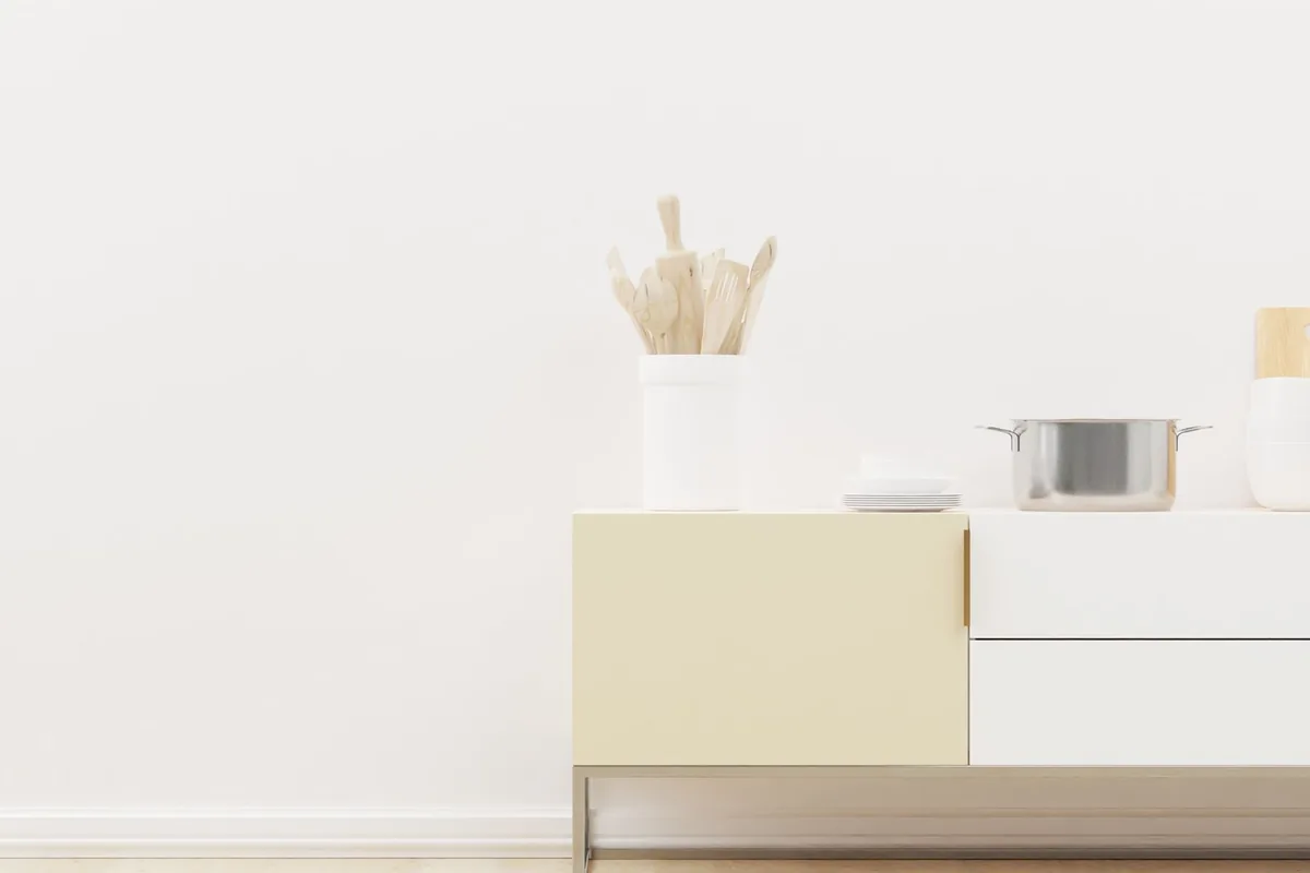 Several stainless steel pots and saucepans with lids arranged on a light kitchen worktop