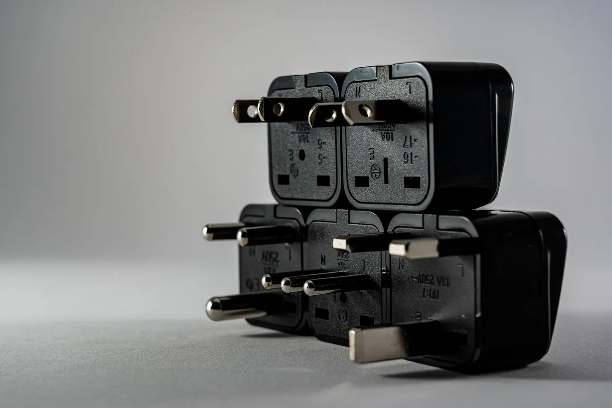Black travel plug adapters stacked together