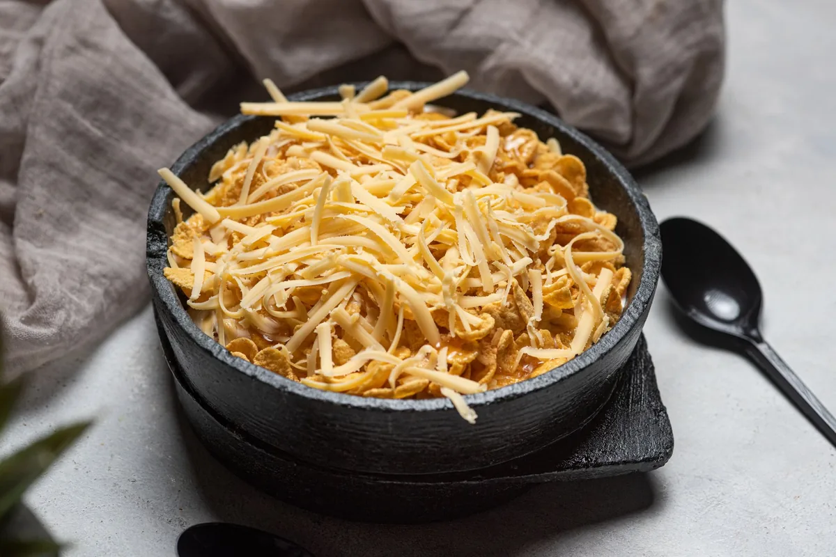 Shredded cheese heaped in a dark stone bowl
