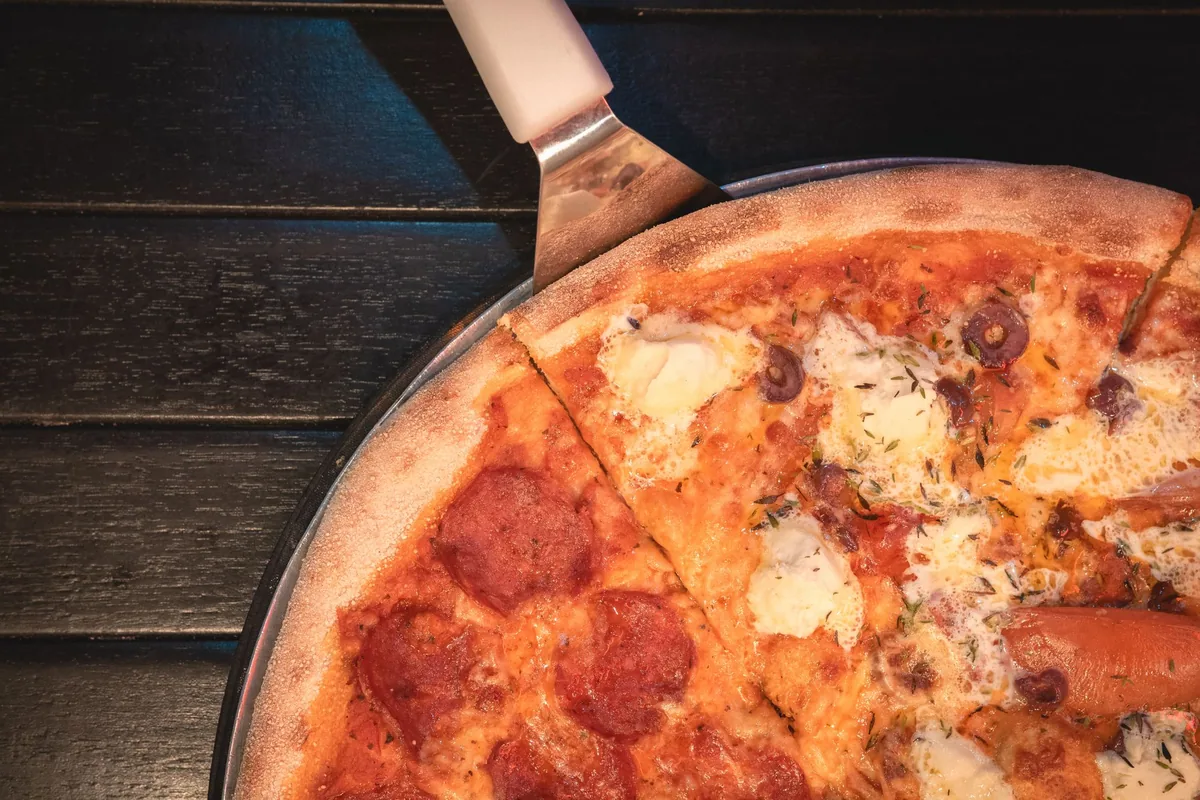 Sliced grilled pizza on an outdoor table