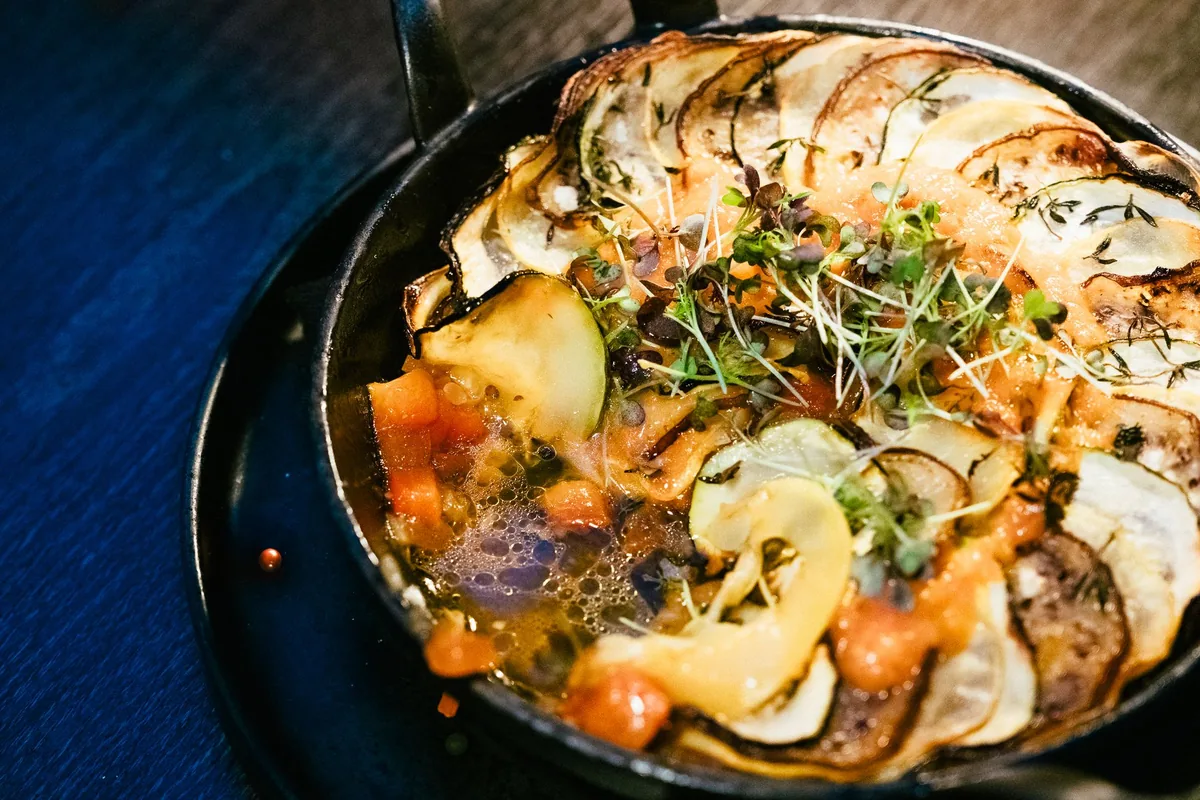 Sliced vegetables layered in a round skillet