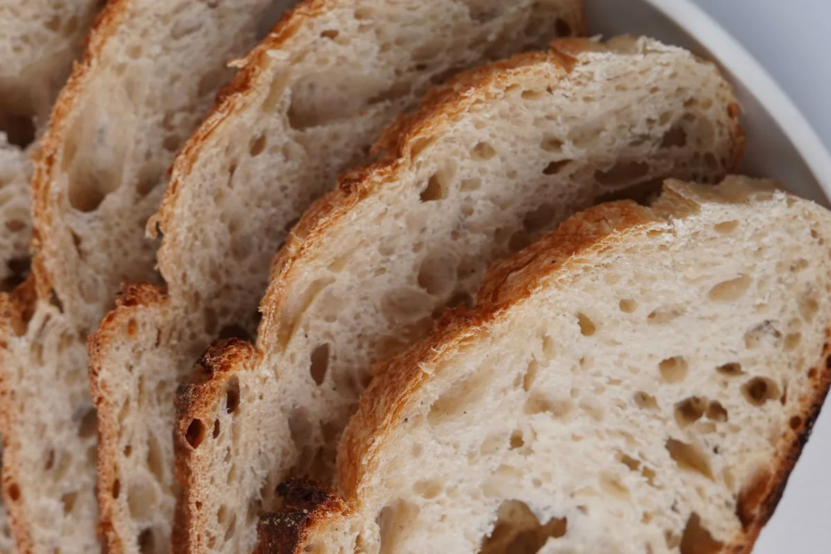 Slices of artisan sourdough showing an open crumb and dark crust