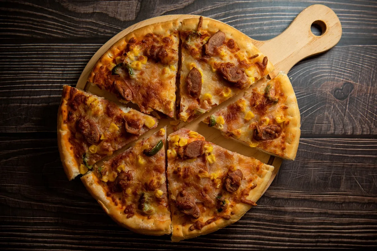 A sliced pizza on a wooden board