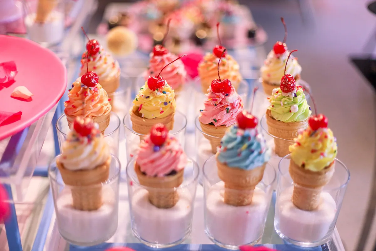 Small glass cups filled with soft ice cream on a light wooden table