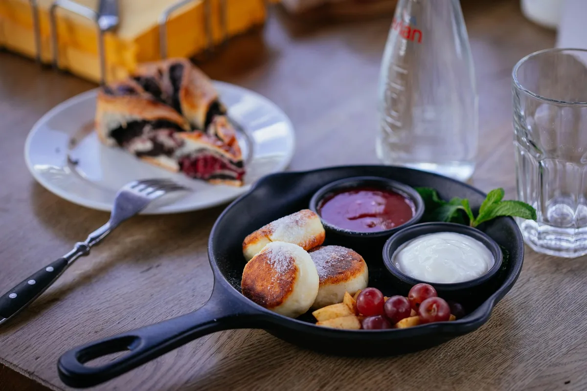Small pancakes with dips in a cast iron skillet on a table