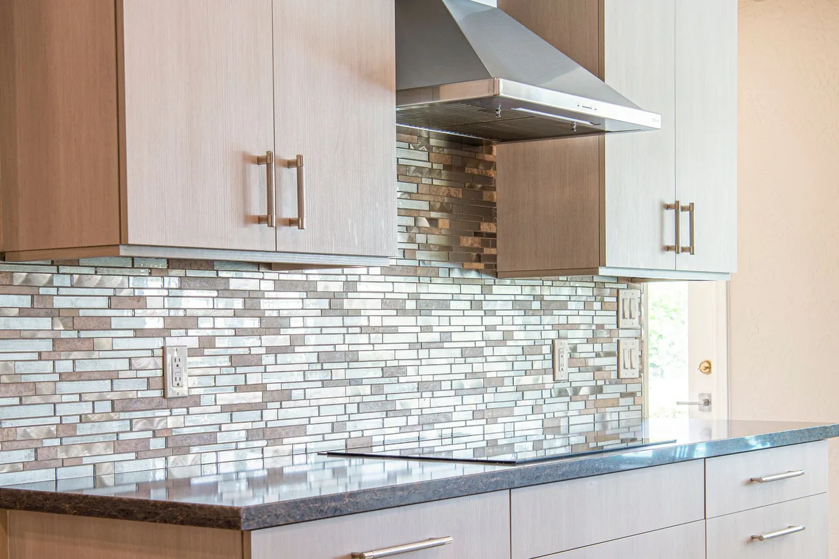Smooth white tiles on a kitchen splashback above a worktop
