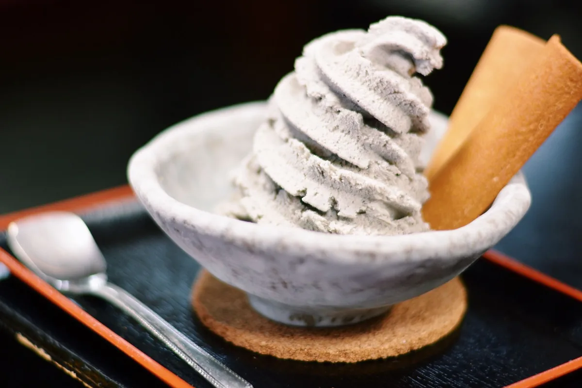 Soft serve ice cream in a ceramic bowl with a wafer