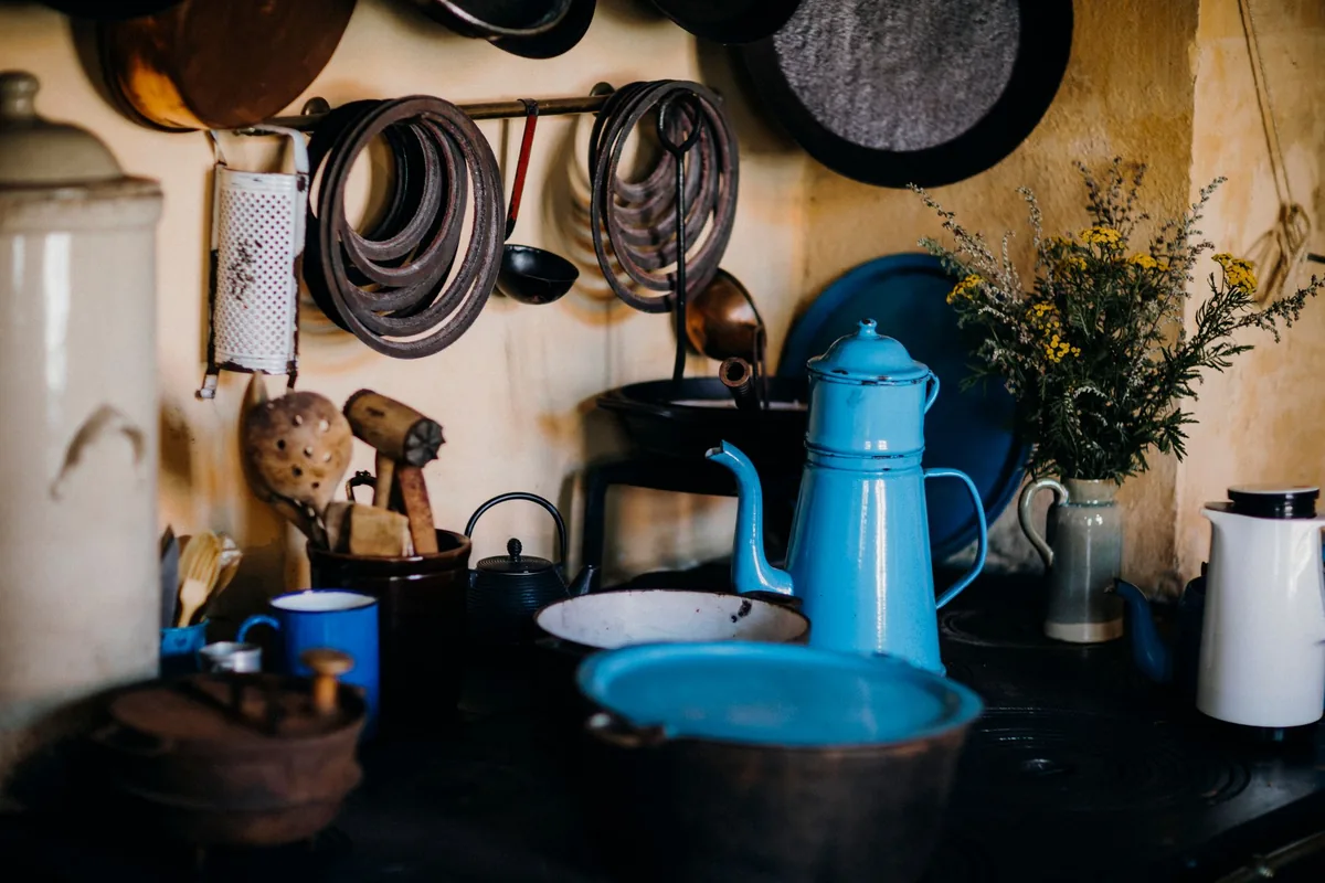 Pots and utensils hanging above an old stove