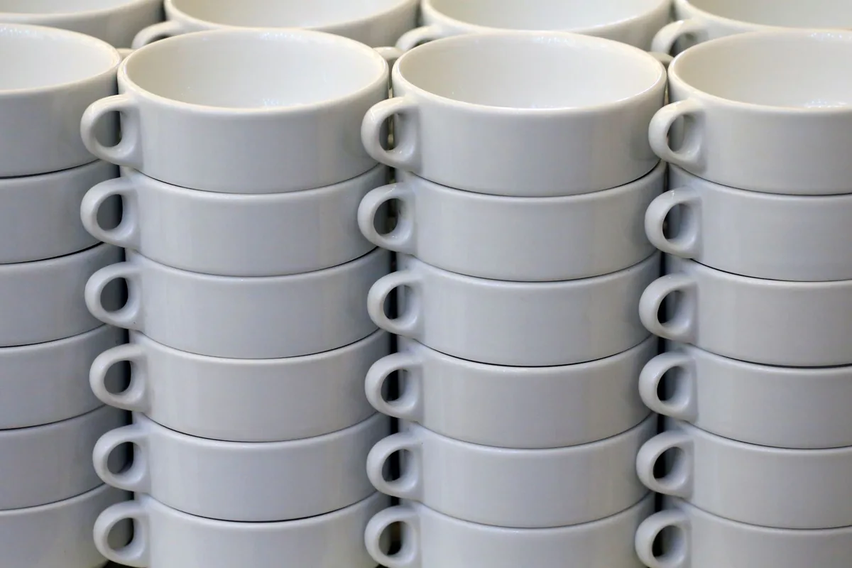 Stacks of white cups on a shelf