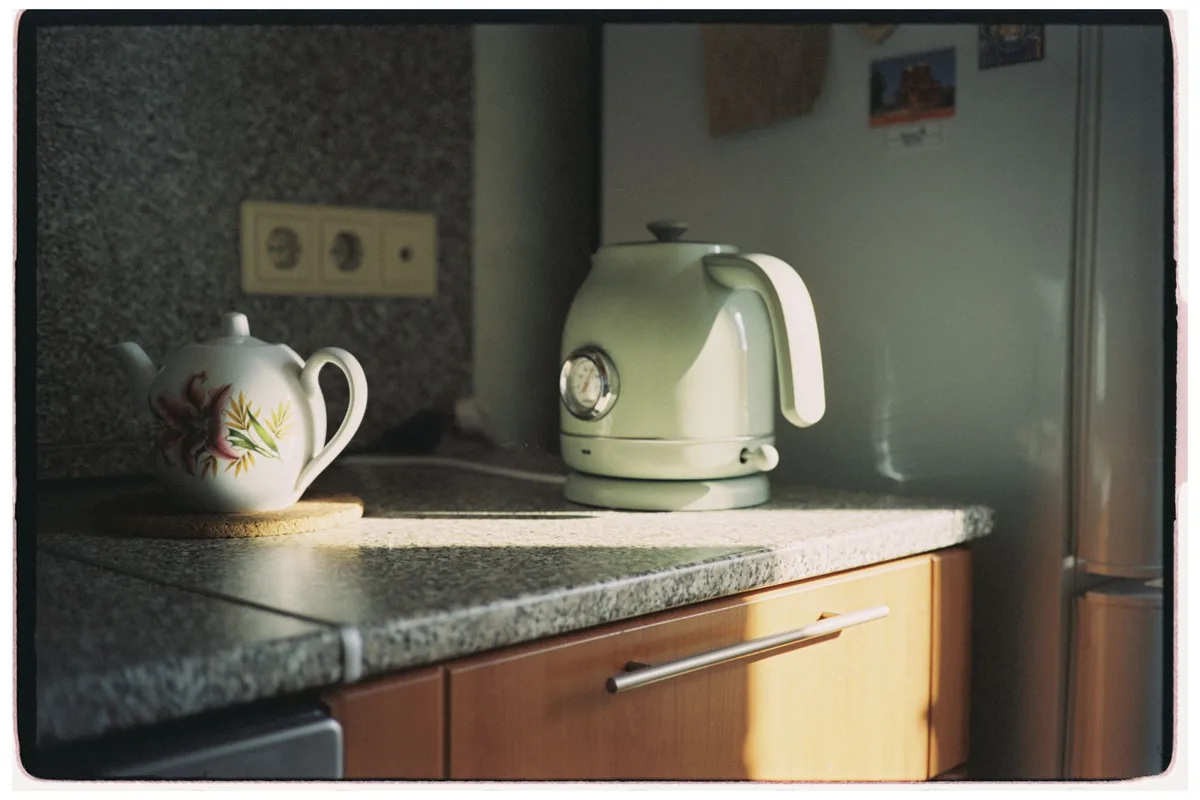 A teapot and a green electric kettle on a kitchen counter