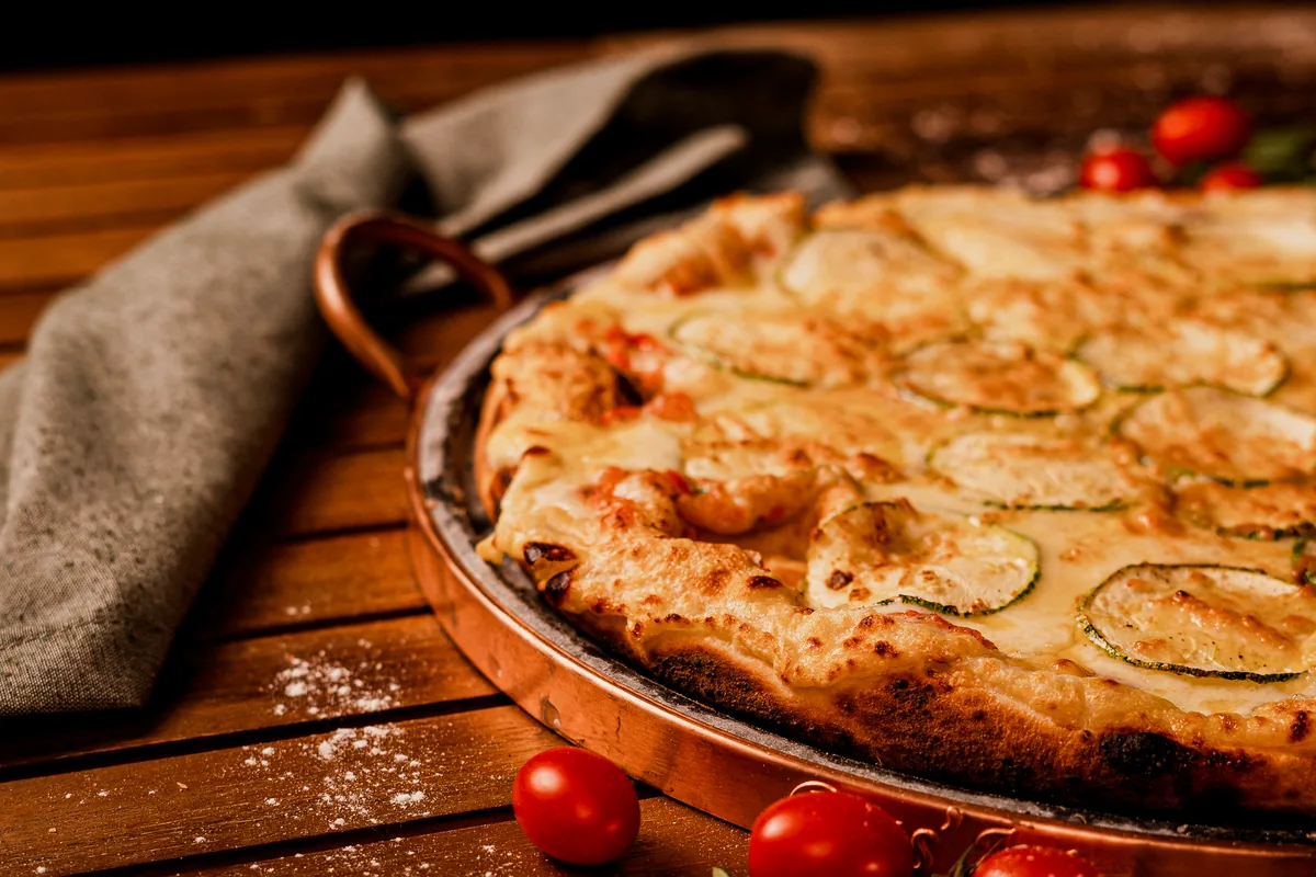 Thick pan pizza with a golden crust on a tray