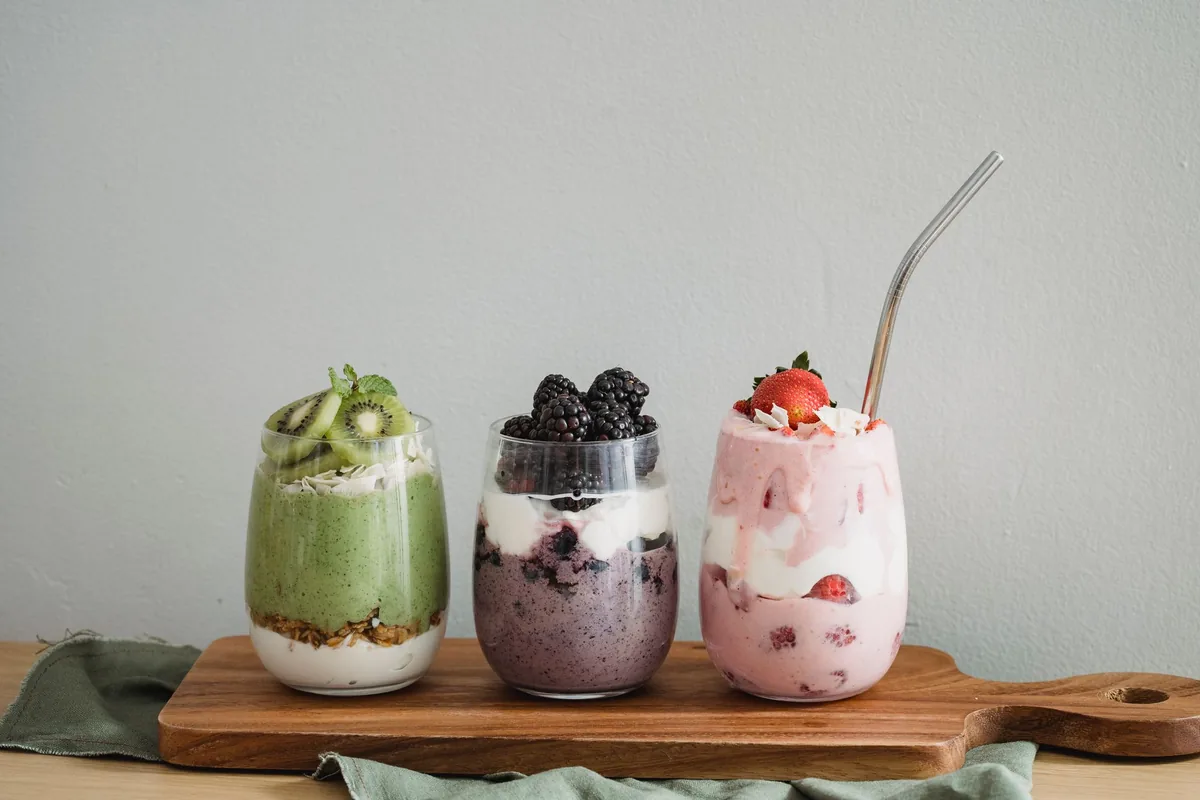 Three layered smoothie jars on a wooden board