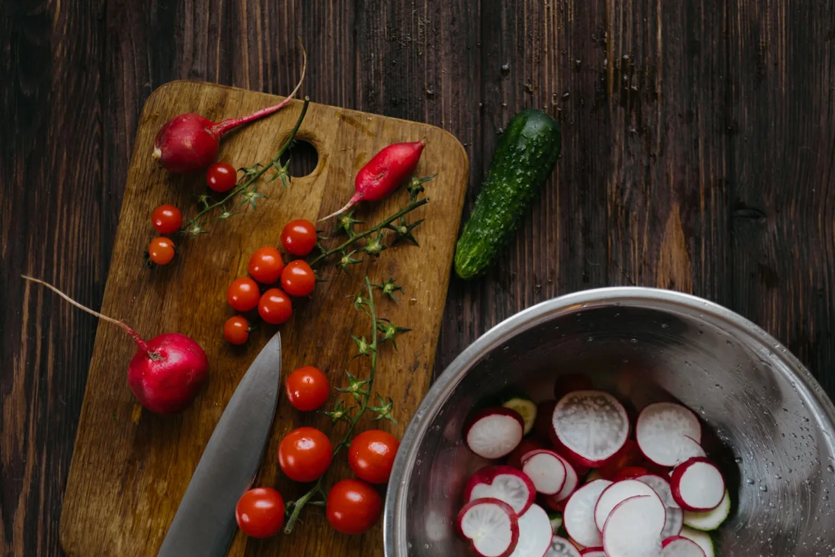 Tomatoes and peppers on a wooden cutting board