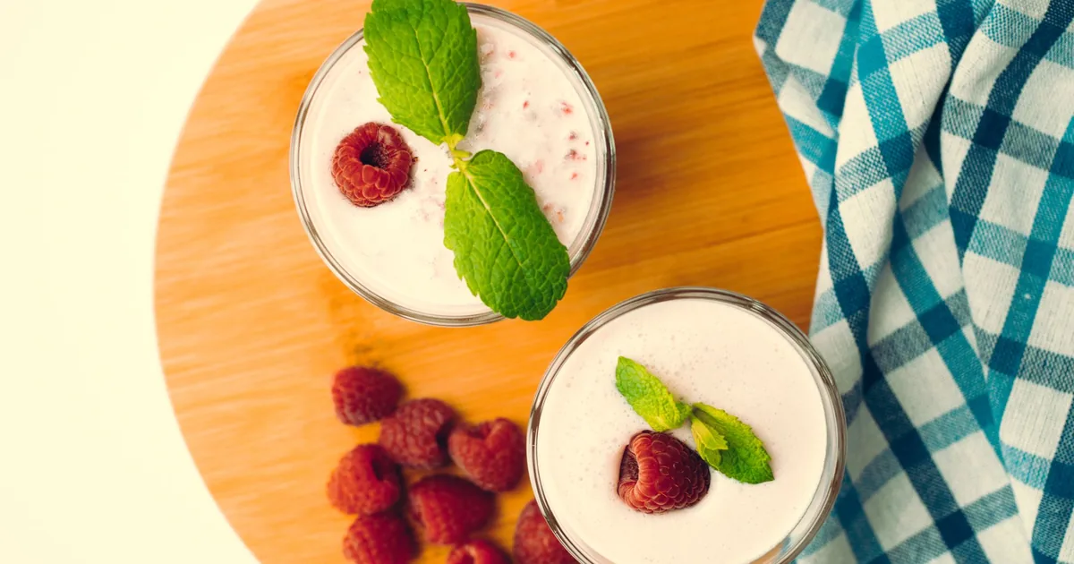 Two bowls of berry smoothie topped with mint, seen from above