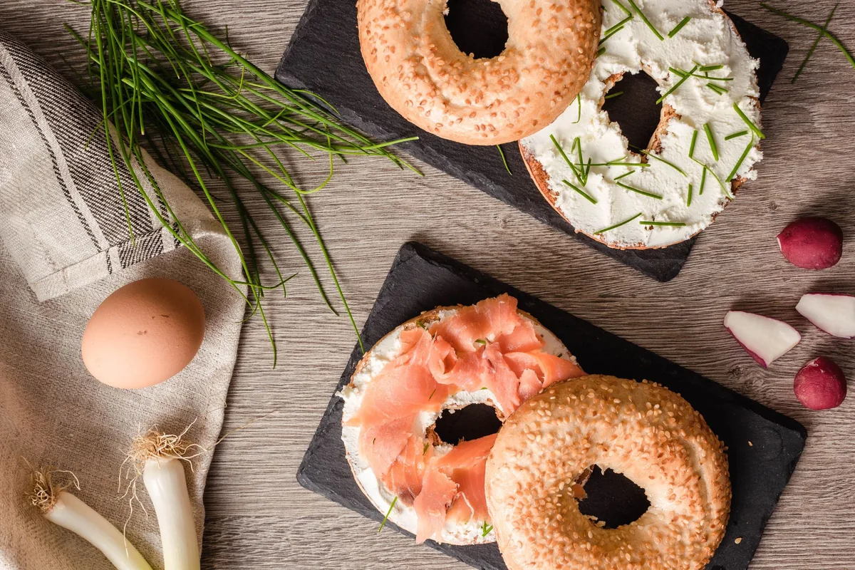 Bagels with cream cheese and salmon on slate boards
