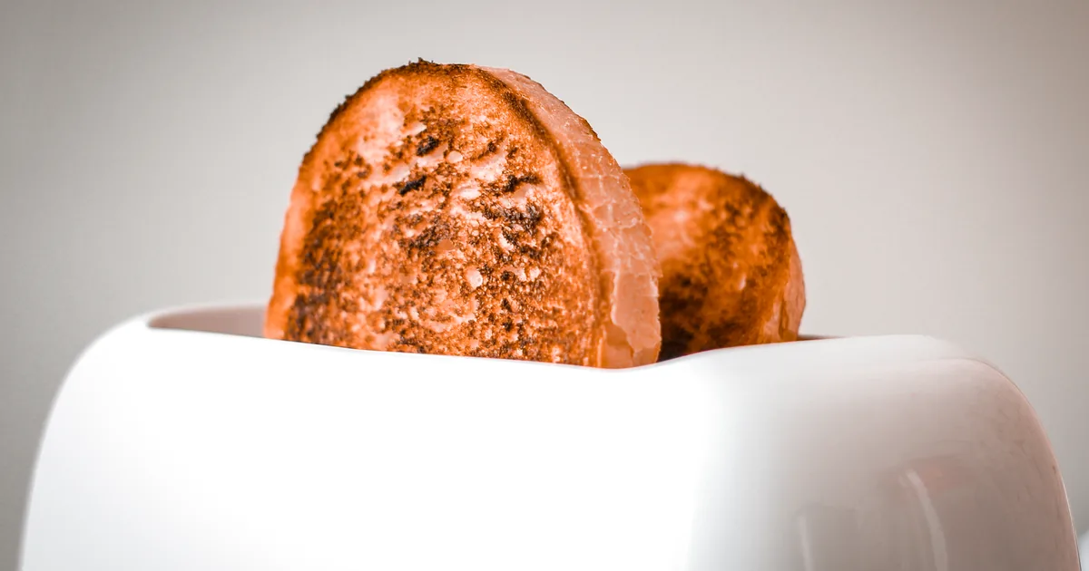 Two slices of toast in a white toaster