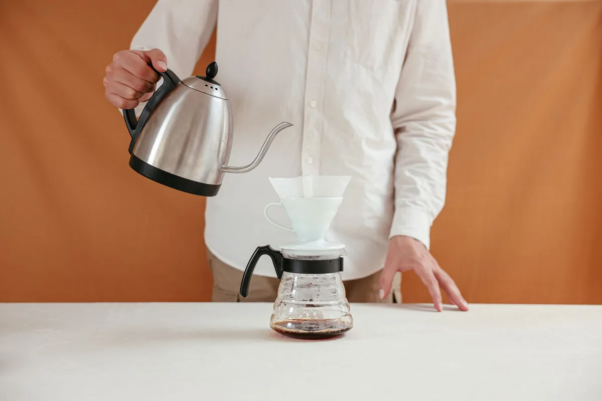Water being poured in a slow spiral over ground coffee in a paper filter