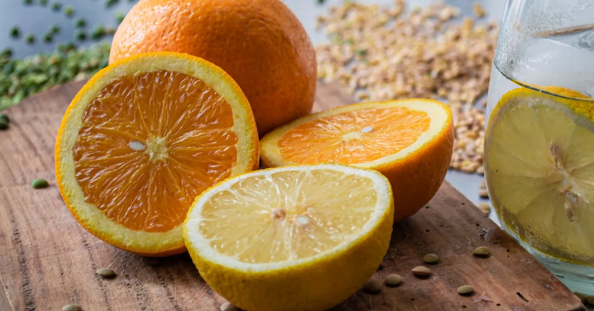 Whole and halved oranges and lemons arranged on a bright kitchen worktop