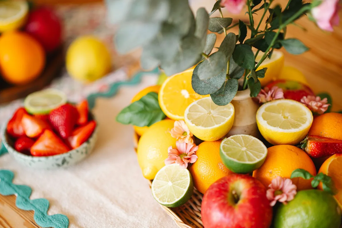 Whole lemons and limes piled on a light kitchen table in daylight