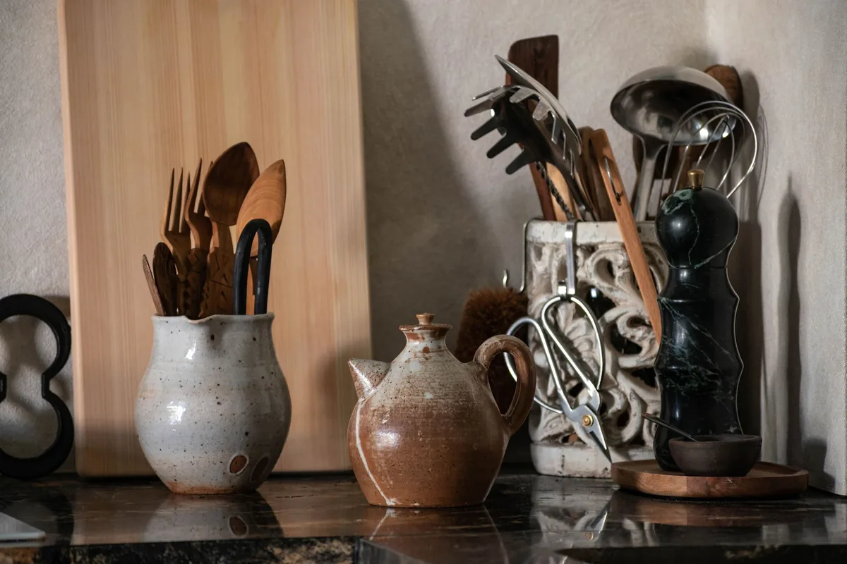 Wooden spoons and utensils in ceramic jars on a counter